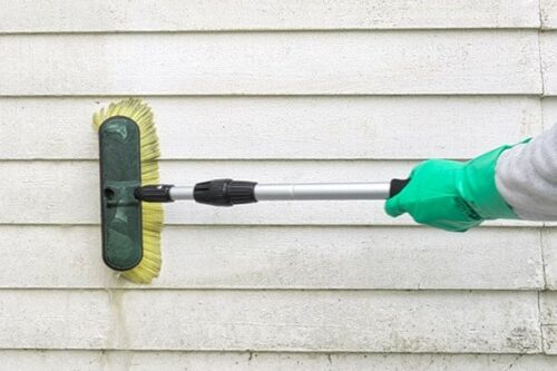 Tvättar fasad med borste